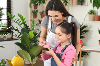 Mother and daughter taking care of houseplants.