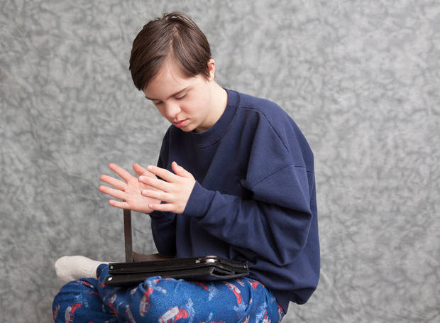 A boy with developmental disabilities uses a tablet app for children with autism