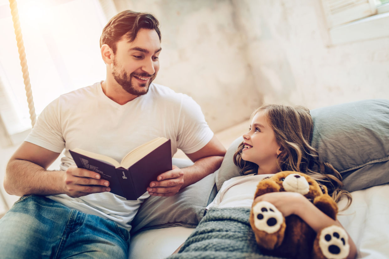A father reads his daughter a bedtime story