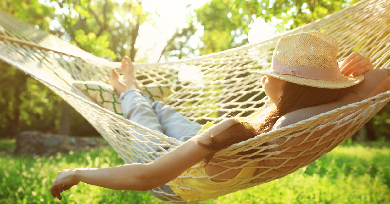 Happy woman relaxes in hammock