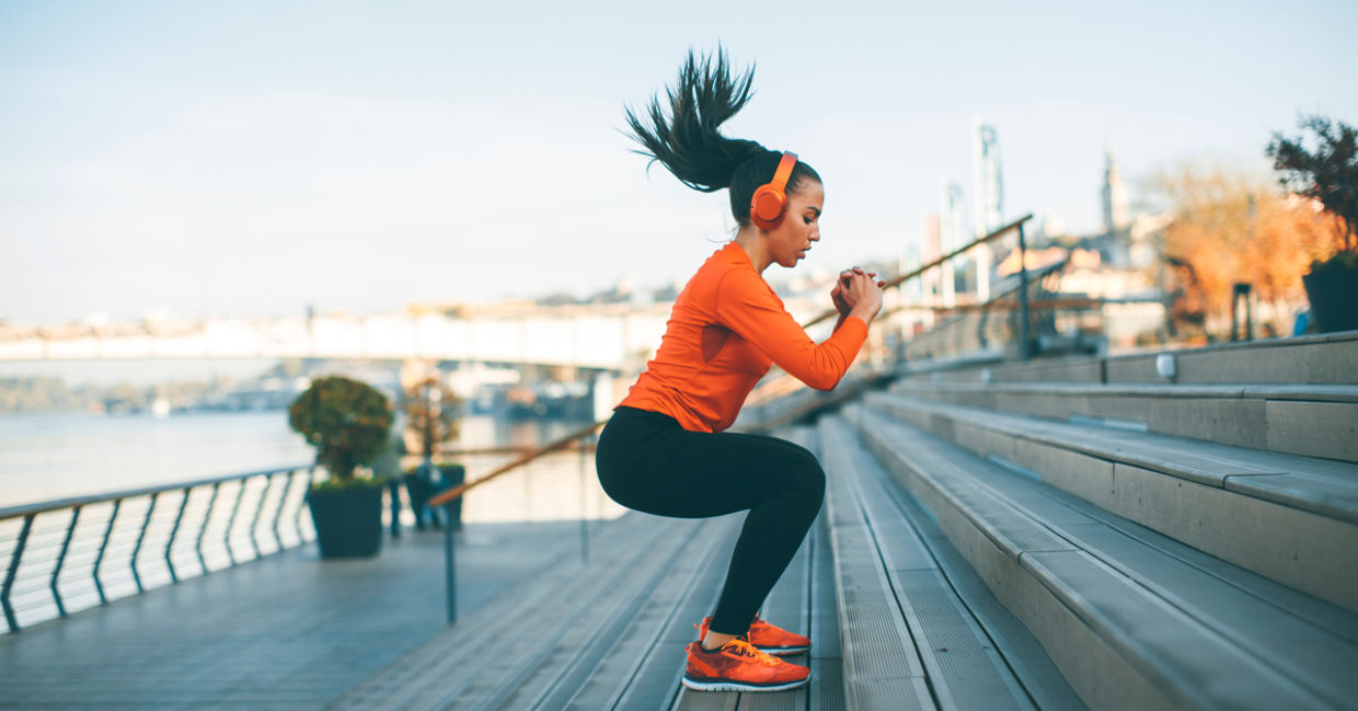 Woman with headphones exercising outside