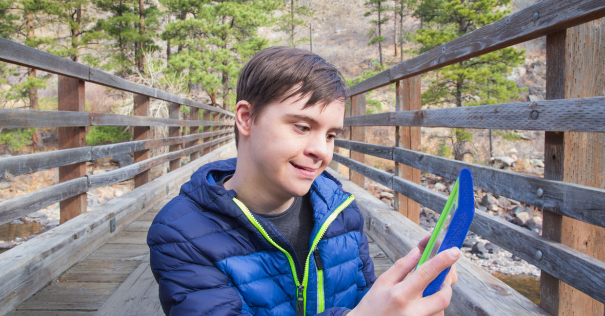 A boy with autism and Down's Syndrome using a tablet app