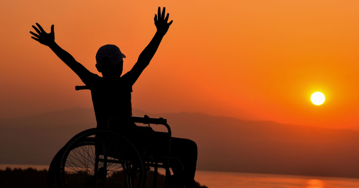 Wheelchair user enjoying a sunset by the sea