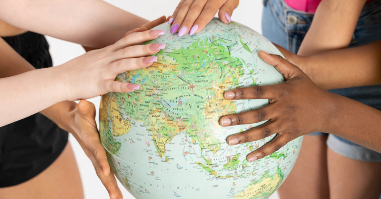 Acceptance and tolerance is depicted with multi-racial women embracing a globe.