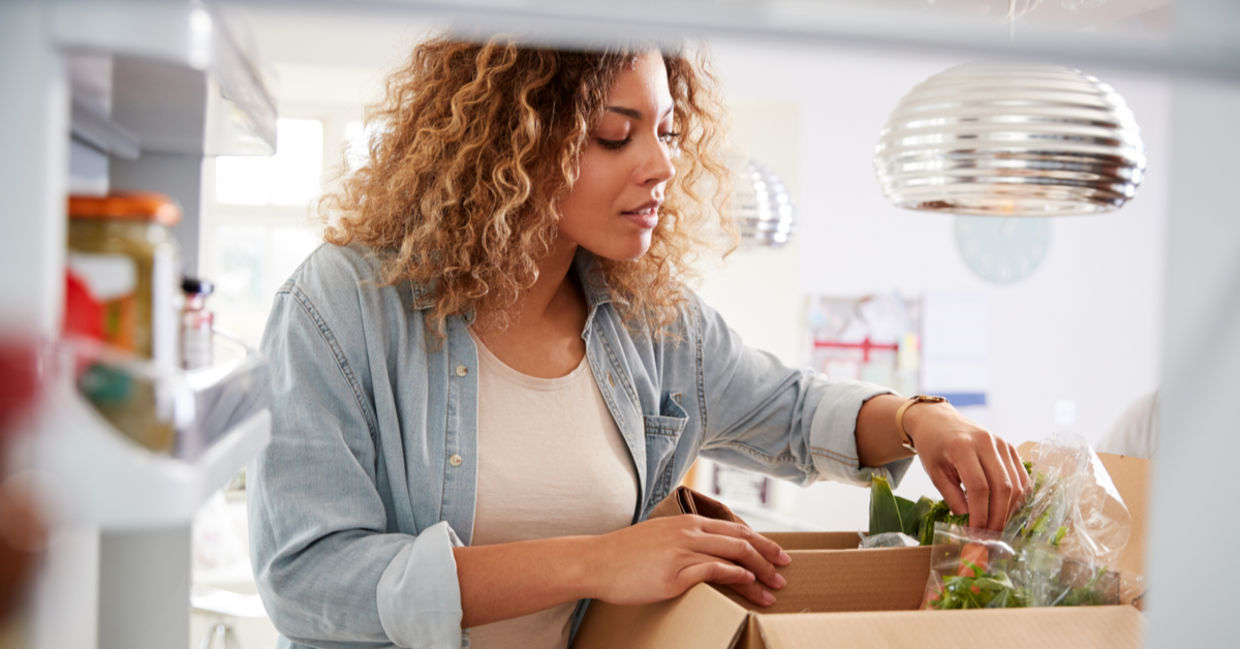 Woman carefully unpacks home food delivery