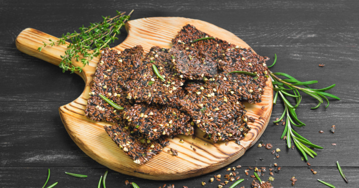 Freshly made flaxseed crackers with sprigs of fresh rosemary.