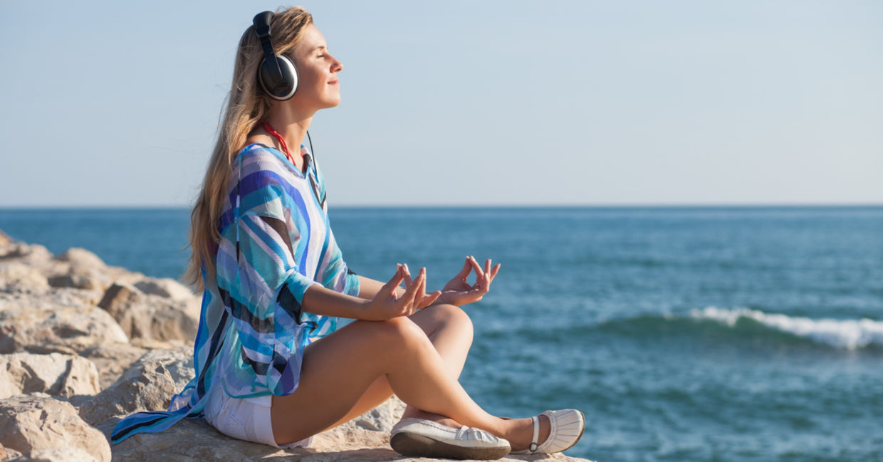 A woman meditates to the relaxing soundwaves of binaural beats.