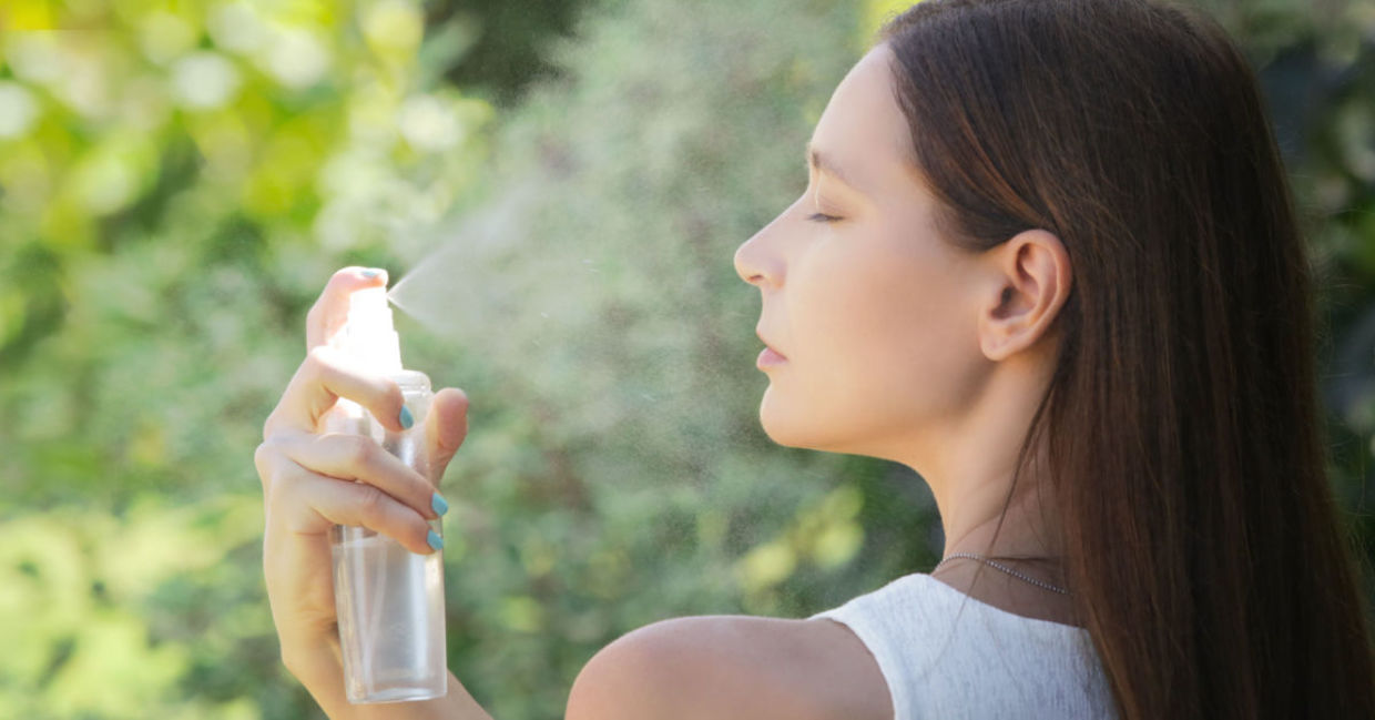 Woman using a refreshing face spray.