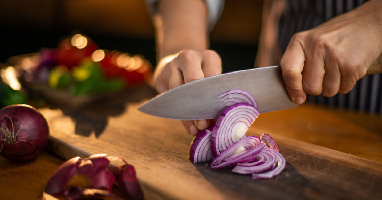 Chef cutting red onions.