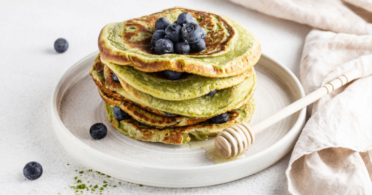 Matcha pancakes topped with blueberries.