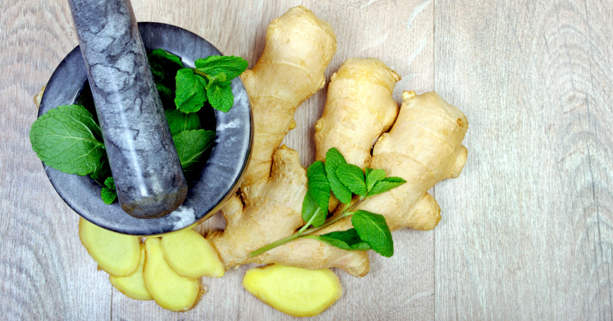 Whole and sliced ginger with mint leaves