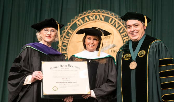 Board of Visitor Karen Alcalde and President &Aacute;ngel Cabrera present graduation speaker Shari Arison with an honorary doctor of humane letters during Winter Graduation at the Fairfax campus.