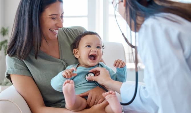 A baby smiles during a medical checkup.