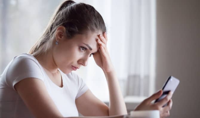 Sad woman reading a rejection email.