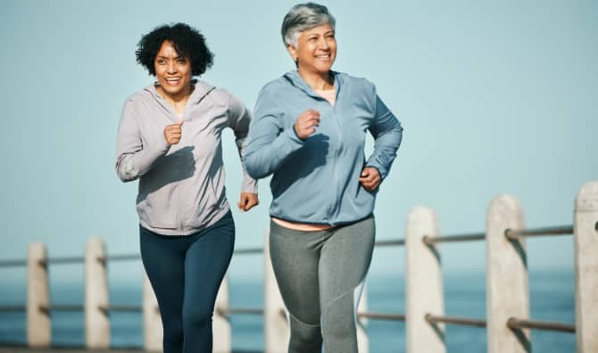 Senior women running on a boardwalk.