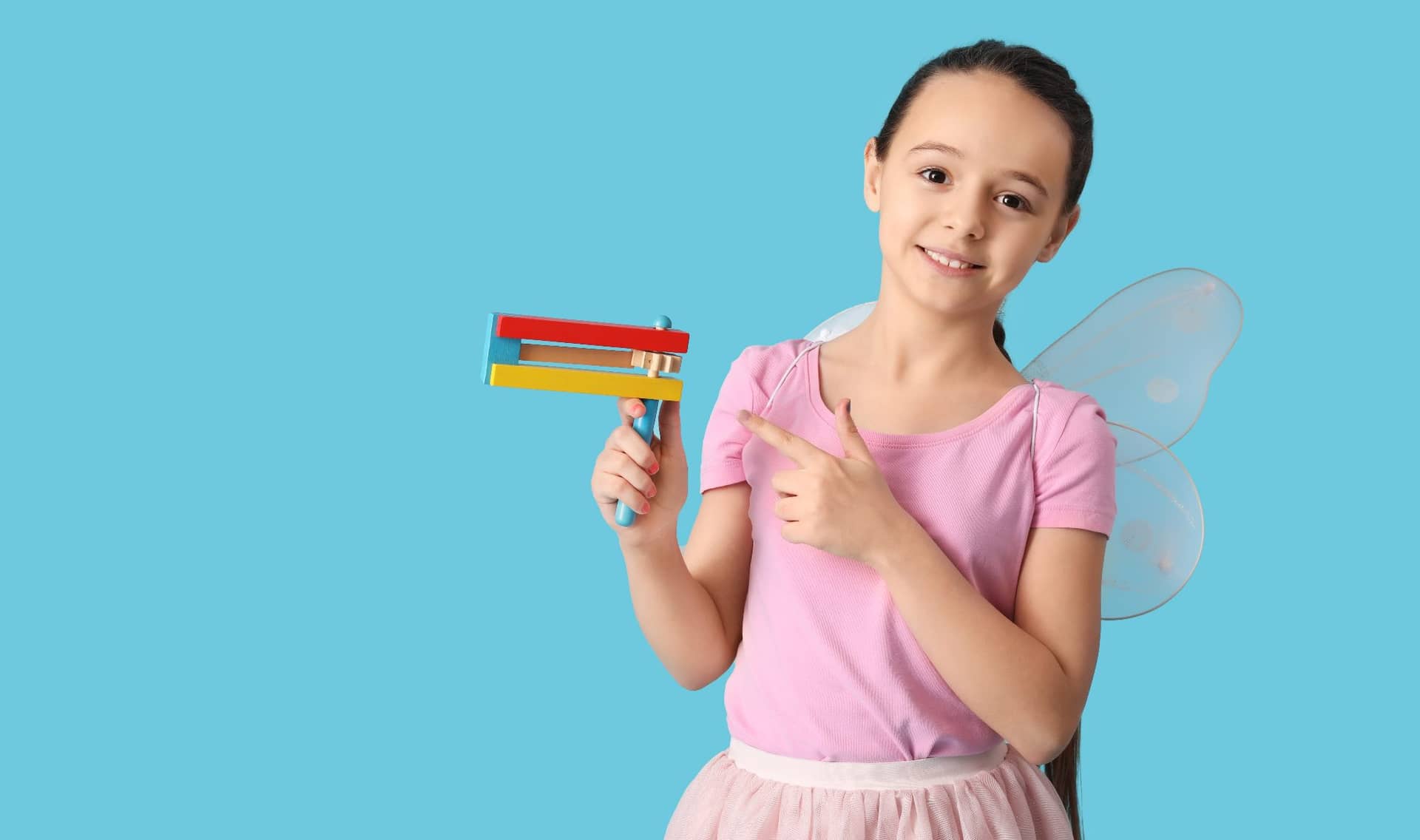 A girl in a fairy costume holding a gragger.