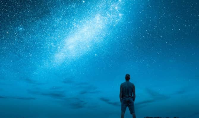 A person stargazes at a night sky.