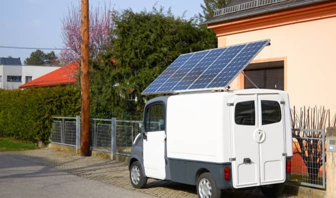 A car with a solar panel battery on the roof.