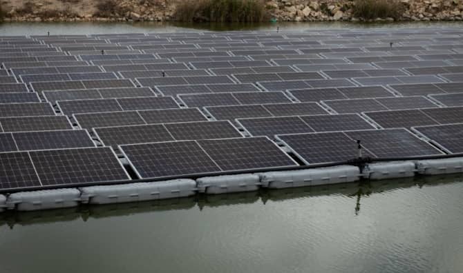 A solar panel system installed above a fish pond.