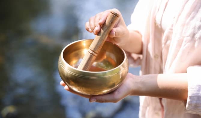 Woman with singing bowl in nature