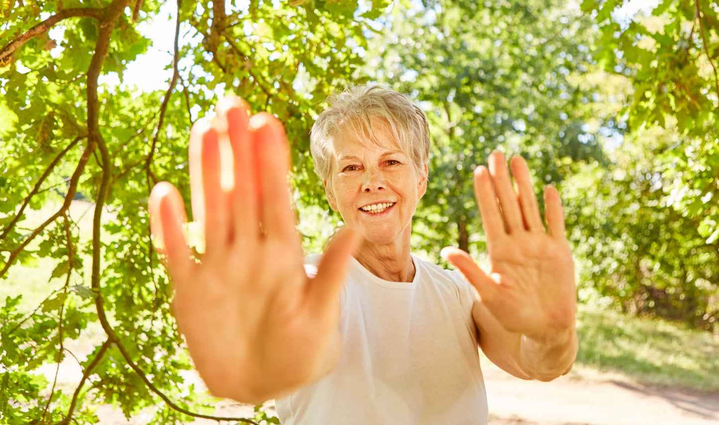 Woman performing tai chi in a park.
