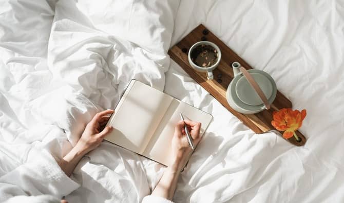 A person writes in a journal.