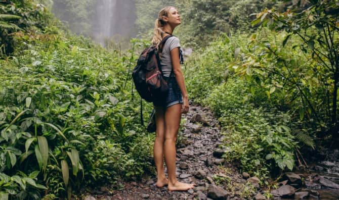 A woman walking barefoot in the forest.