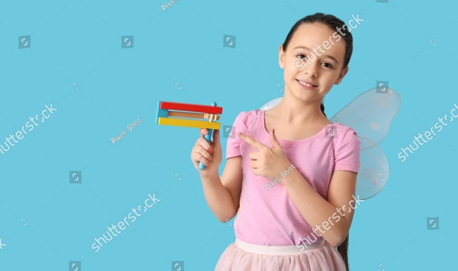 A girl in a fairy costume holding a gragger.