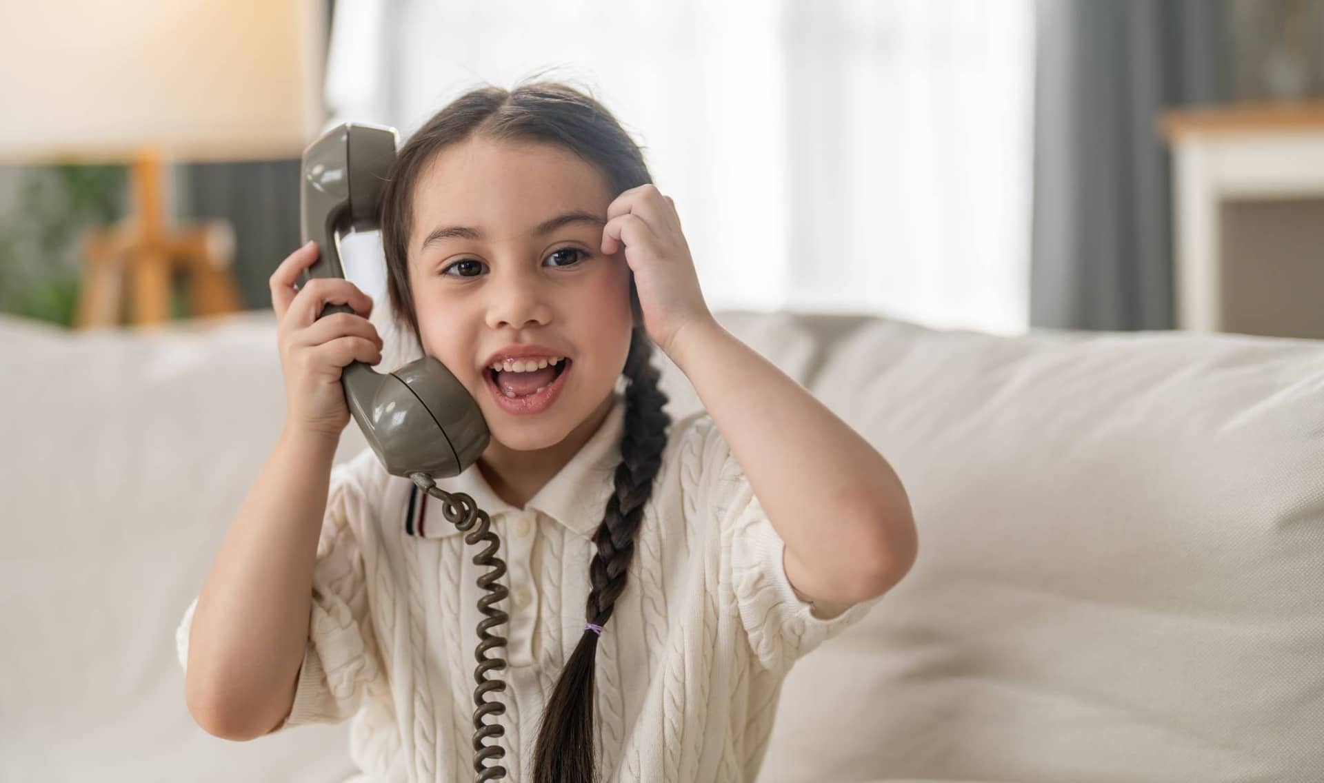 A happy girl talking on vintage retro telephone.