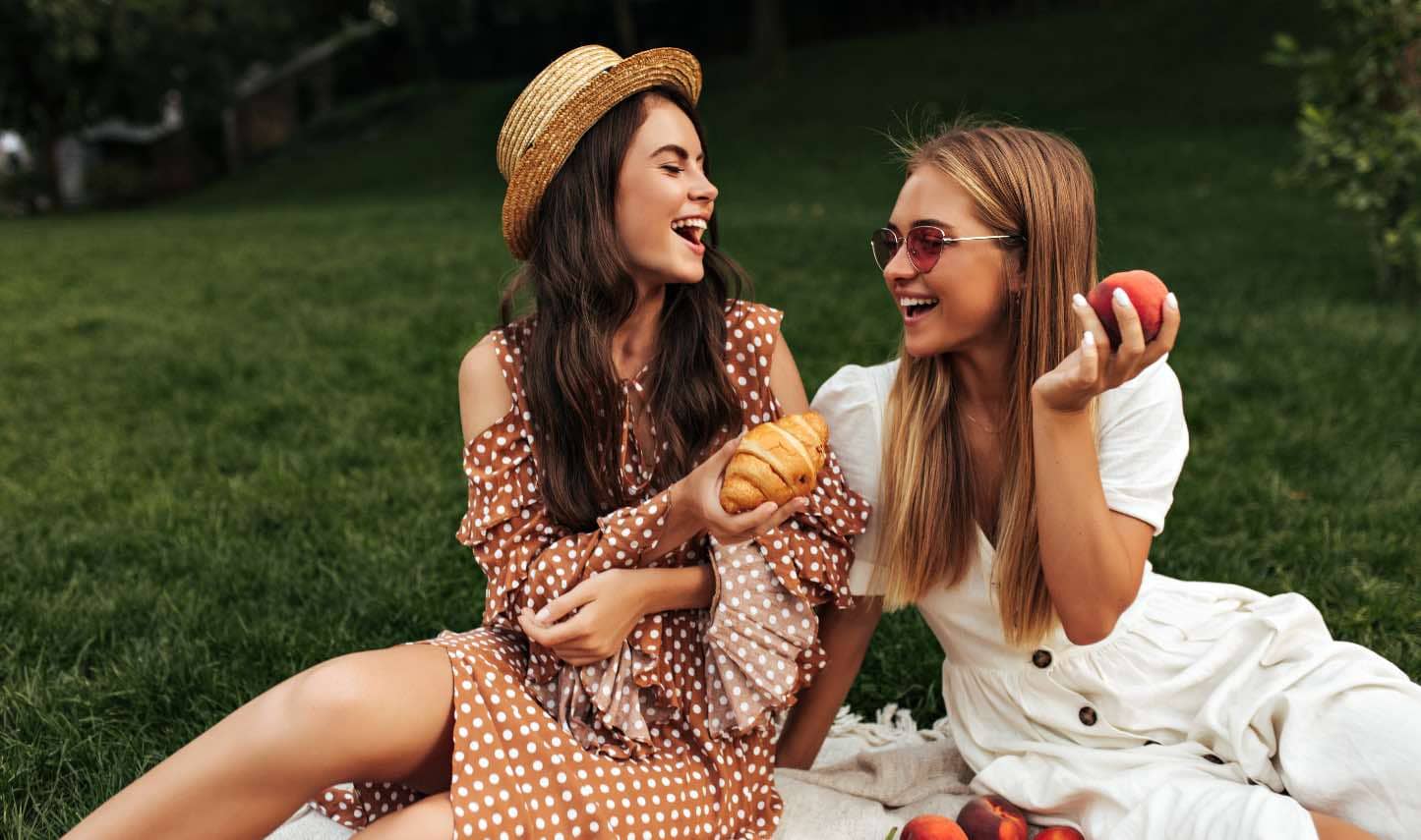 Two women having a picnic outside.