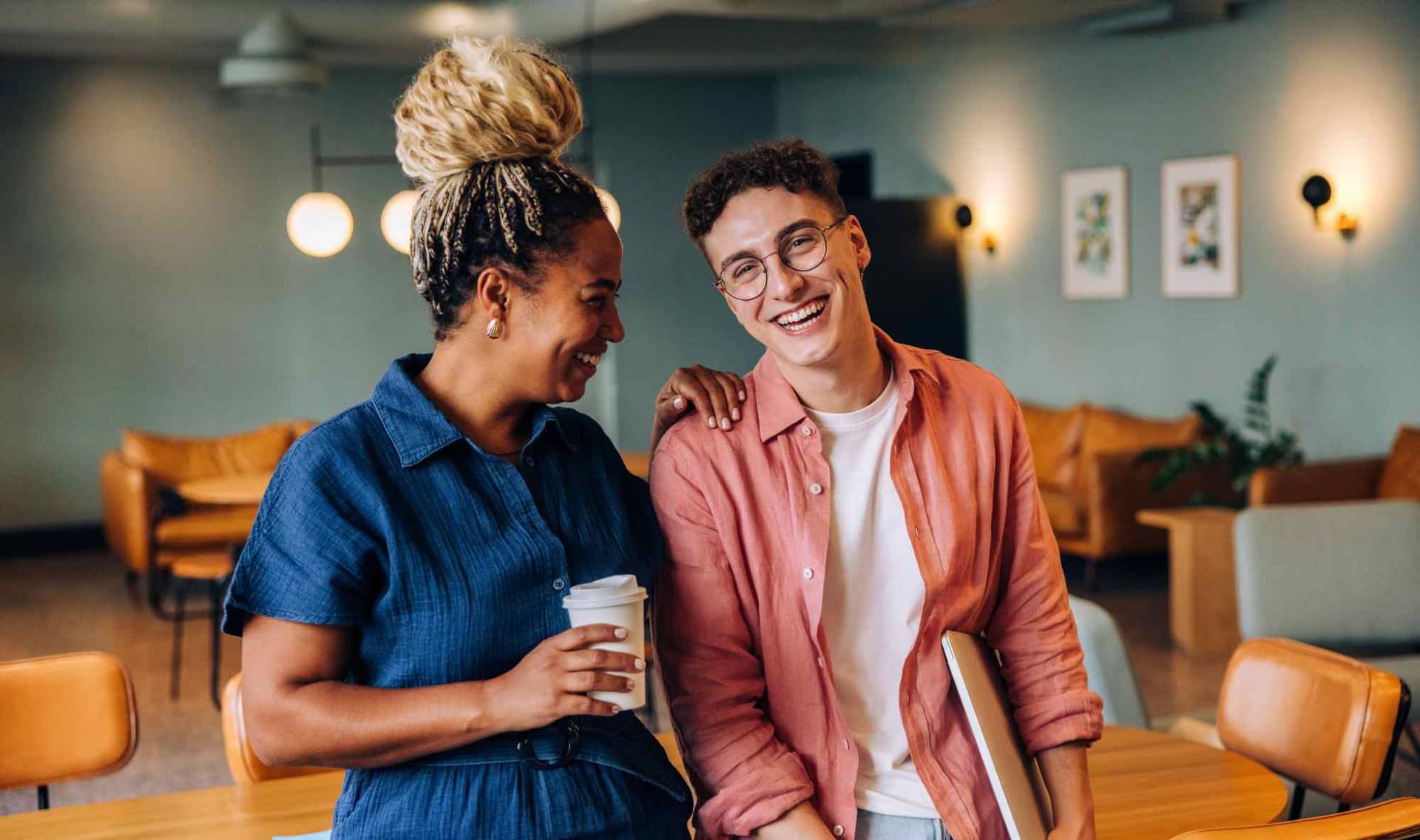 Two coworkers smiling and standing in an office.