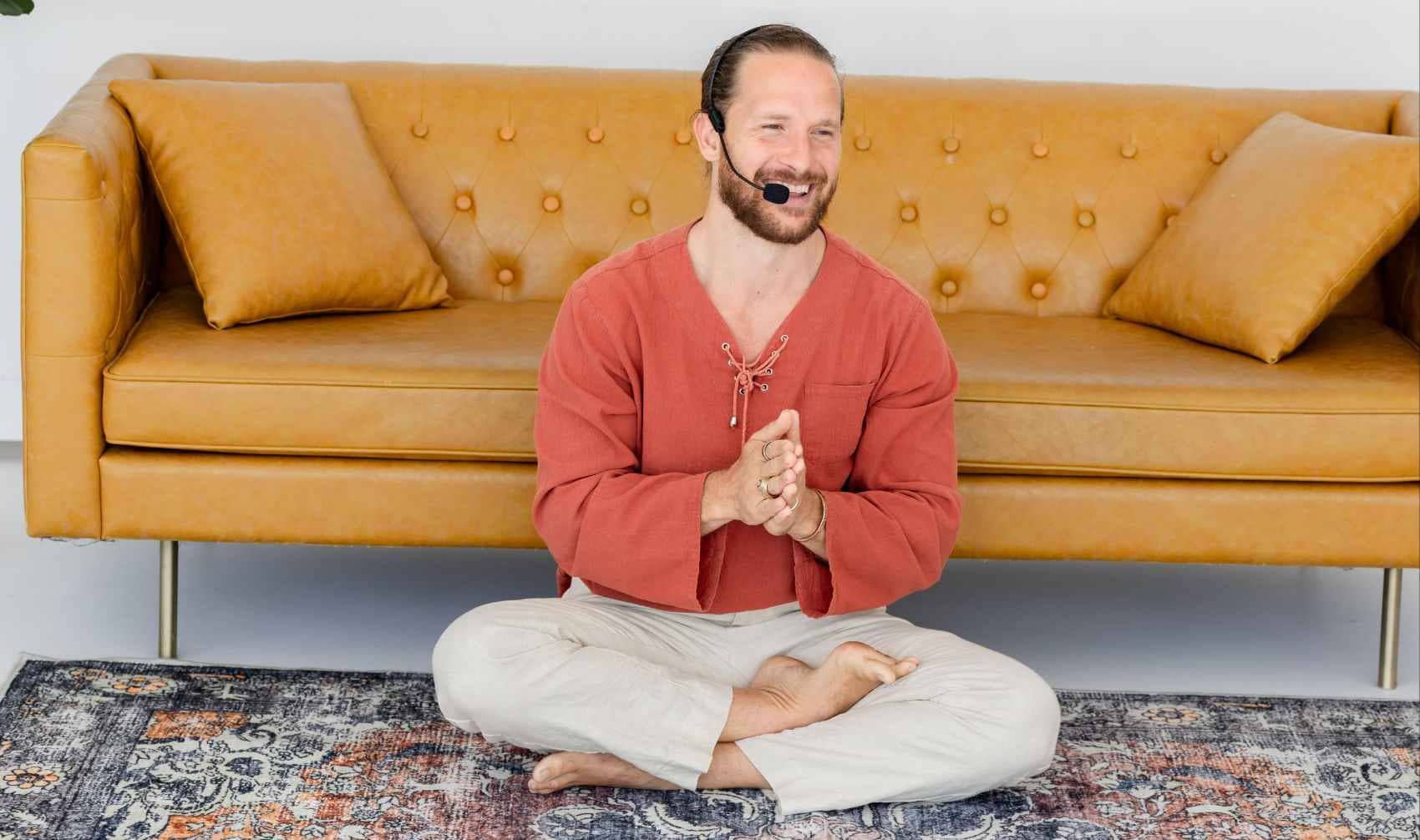 A man sits on a carpet.
