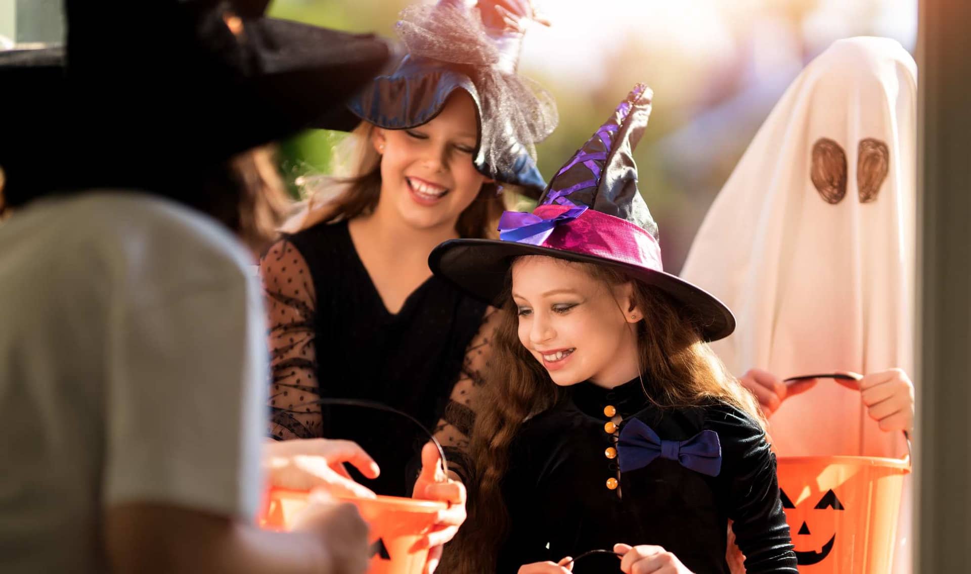 Happy children receiving candy on Halloween.