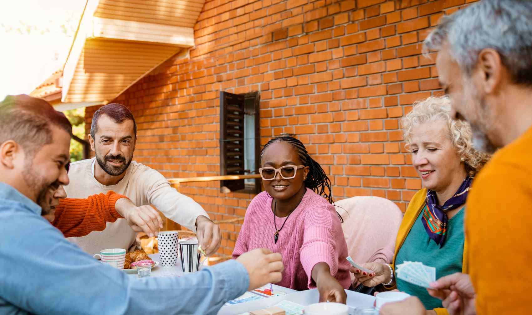 A group of people playing a strategy board game and having fun.