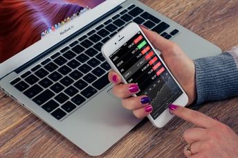 A woman checks a financial app on her iPhone