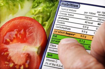 Reading a nutrition label on food packaging with fresh salad background