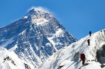 View of Everest from Gokyo valley with a group of climbers on a glacier on their way to Everest base camp