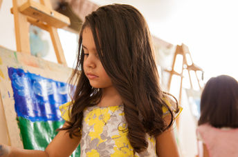 Little girl painting with bright colors