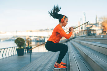 Woman with headphones exercising outside