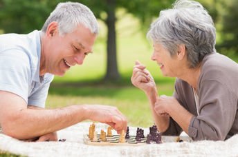 Retired couple playing chess, a brain game.