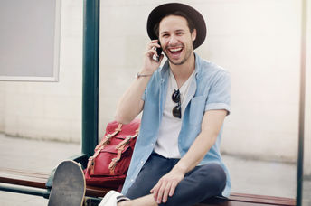 A man laughing at a tram stop.