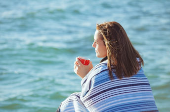 Woman sitting by the sea to manage stress