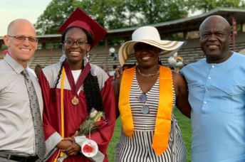 Verda Tetteh poses in her graduation gown with family and her school principal.