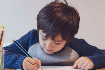 Child writing with a pencil.