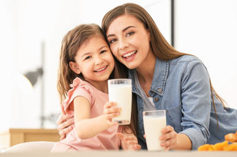 a mother and daughter enjoying vegan milk.
