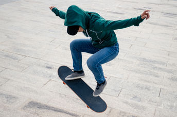 An Asian skateboarder jumps in the air.