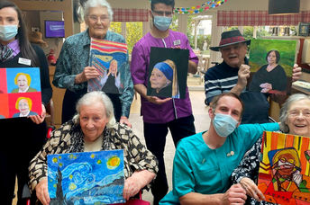 Residents at the Sandfields residential home for seniors pose with some of their art