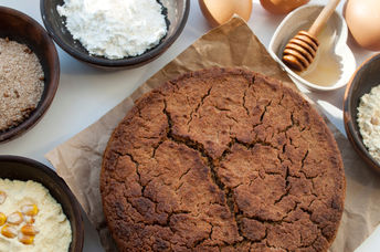 A selection of gluten-free flours beside a healthy freshly baked muffin.