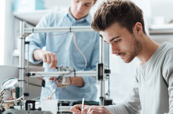 Students in a lab using a 3D printer