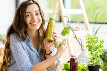 A woman doing a detox shows her healthy smoothies along with detoxifying fruits and vegetables.
